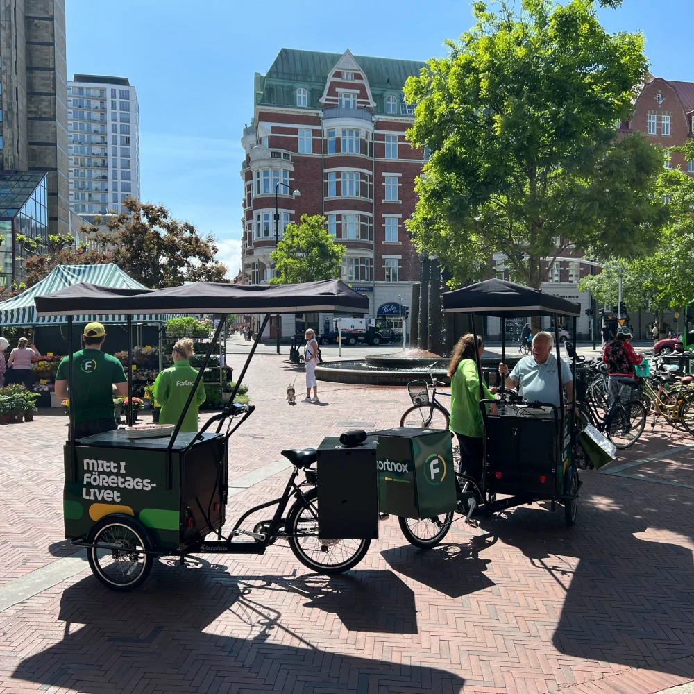 Event staff with branded bikes running an outdoor campaign for Fortnox in a city setting.